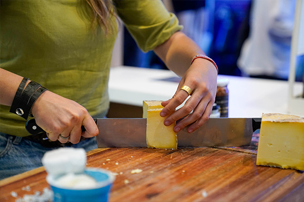 Público recorriendo el evento Hotelga, la exposición líder de hotelería y gastronomía, con el logo institucional iluminado en el área principal.