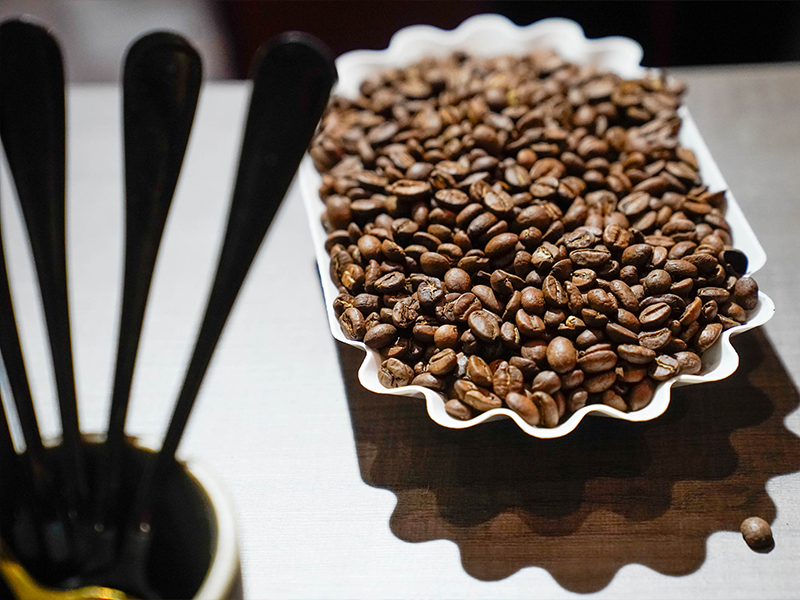 foto de Bandeja con granos de café tostado exhibida en un stand de bebidas y gastronomía en el evento Hotelga.