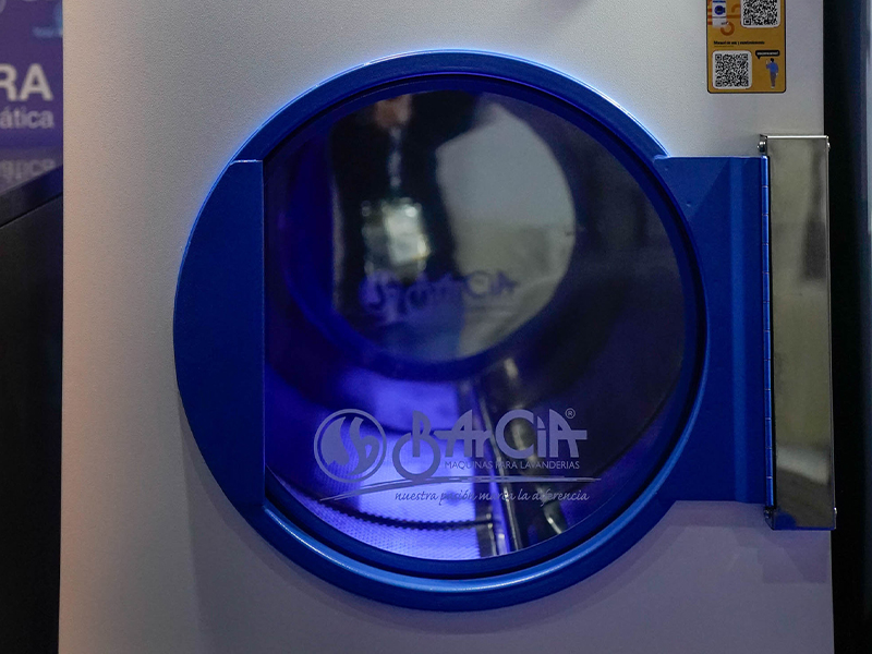 foto de Máquina de lavandería industrial con puerta frontal azul, exhibida como equipamiento profesional en Hotelga.