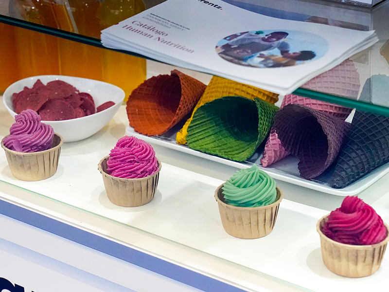 Cupcakes y conos de helado coloridos en un stad de la exposición.