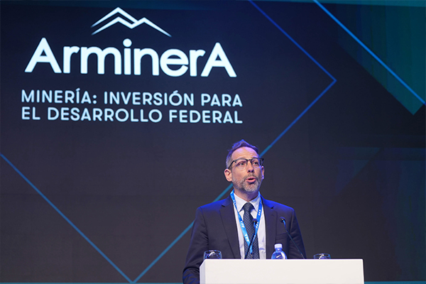 Conferencia en el escenario principal de la exposición Arminera, con pantalla institucional sobre inversión minera y desarrollo federal.