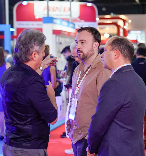 3 hombres reunidos en uno de los pasillos de la exposición Intersec Buenos Aires